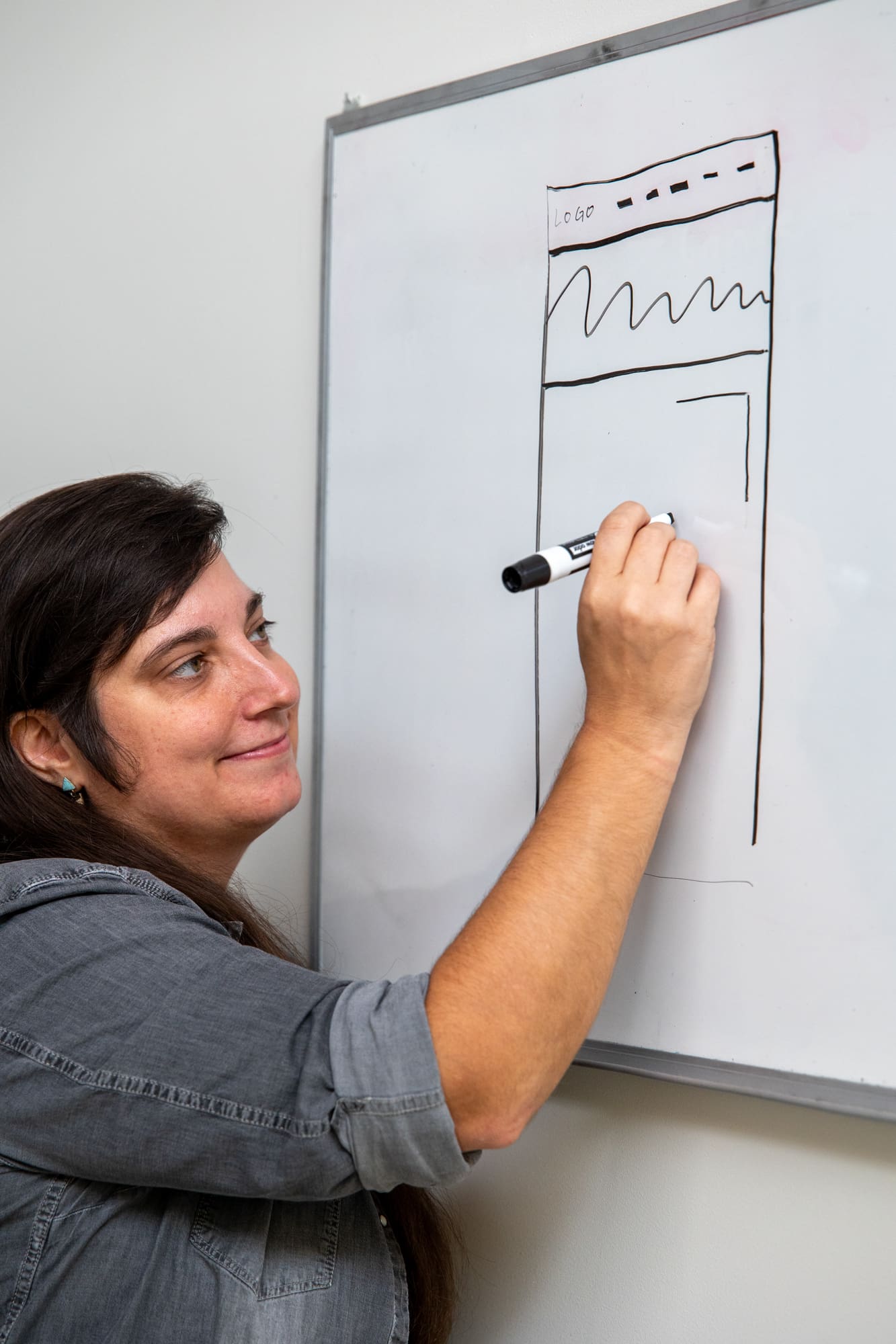 Amanda draws a sketch on a white board