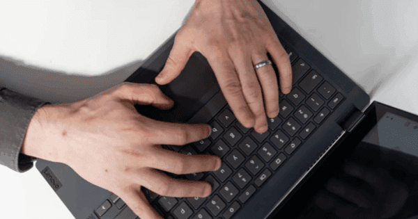 Hands typing on a laptop.