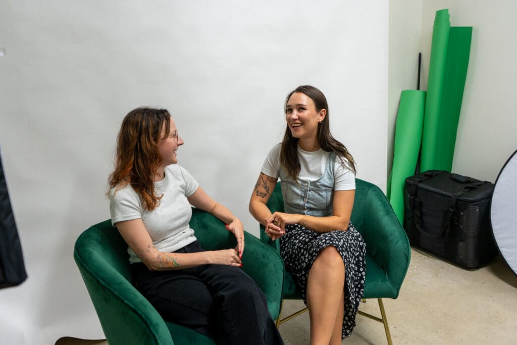 Meara and Bri have a conversation in the Online Optimism creative studio.