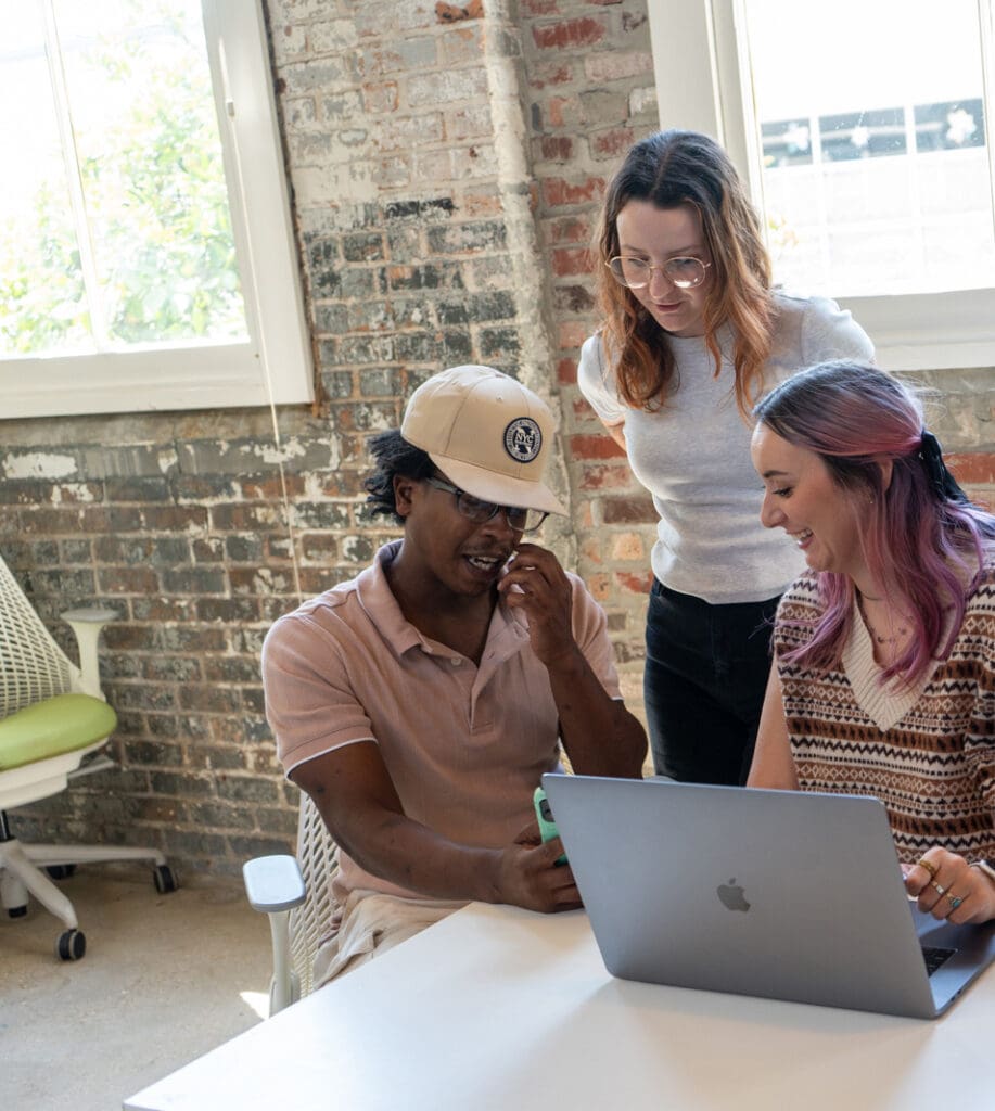 The social media team looks at a laptop together.