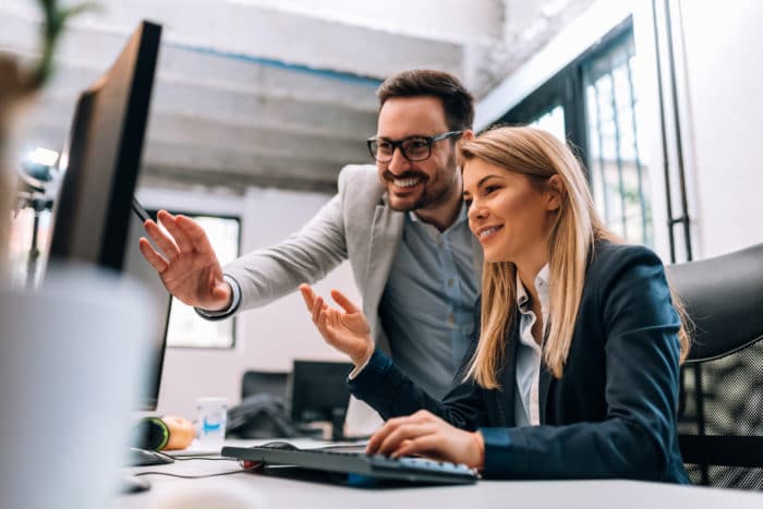 A man and woman professional looking at desktop