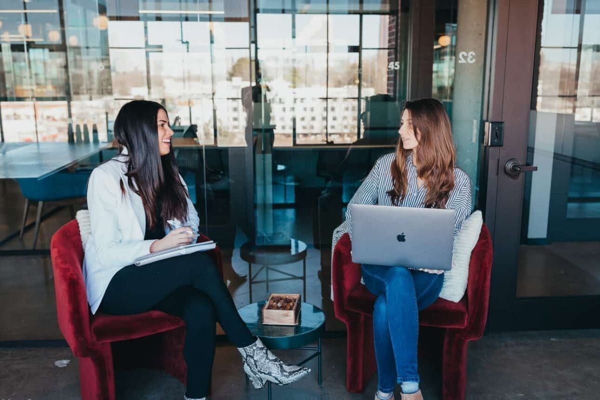 Two Optimists with a laptop and notebook talking