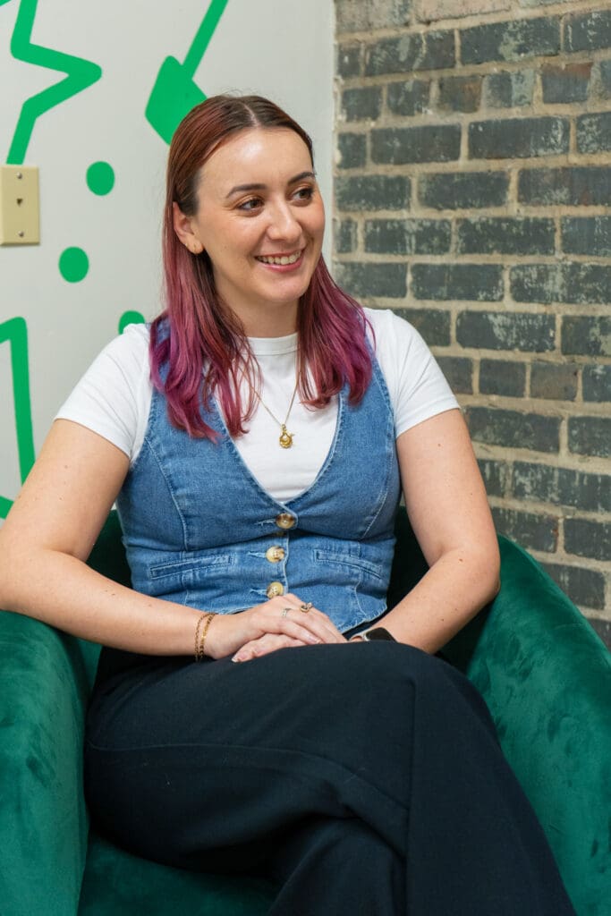 Madi sits in a green chair in the New Orleans office