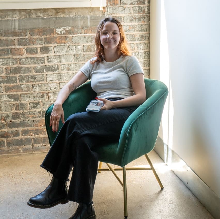 Bri looks up from a social media feed on her phone and smiles.