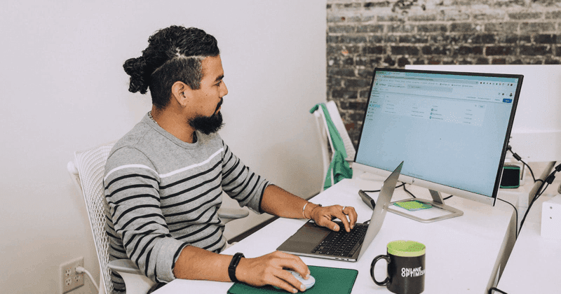 Esteban reviews a Google Tag Manager container on his computer in the office.