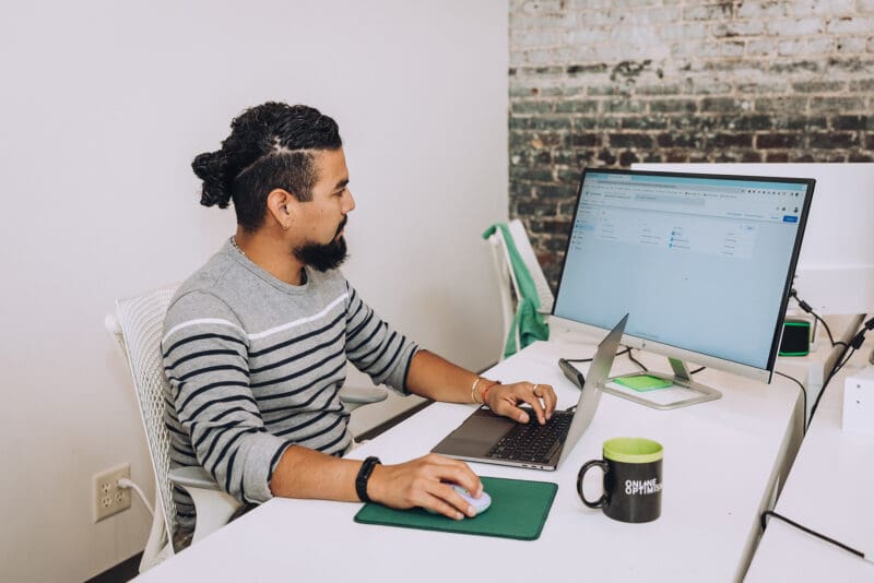 Esteban reviews a Google Tag Manager container on his computer in the office.