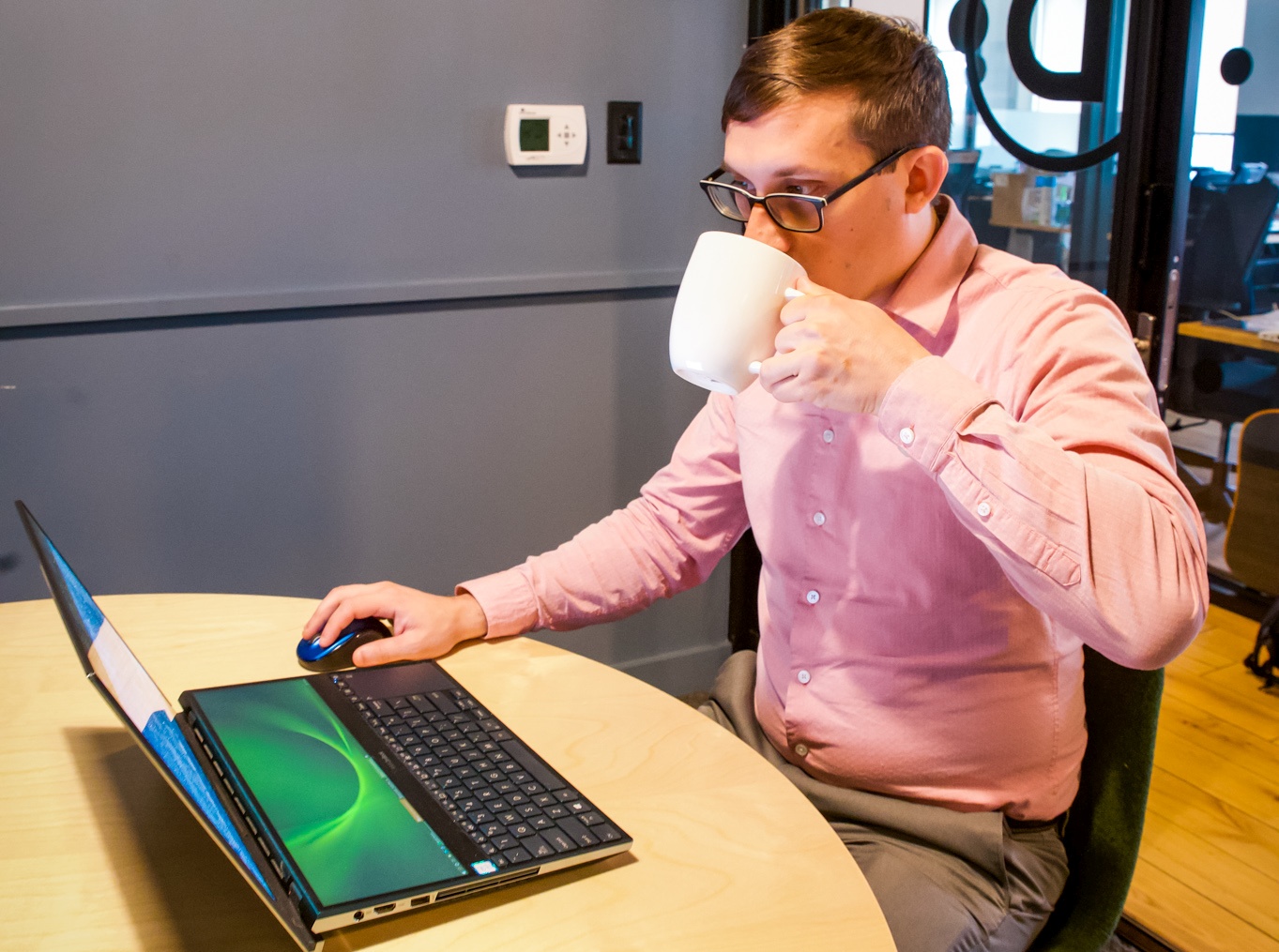 Flynn Sipping Coffee While Working on his Laptop in our Atlanta Offices