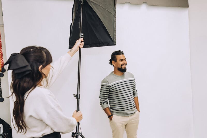 Jordan points a studio light at Esteban in the Online Optimism creative studio