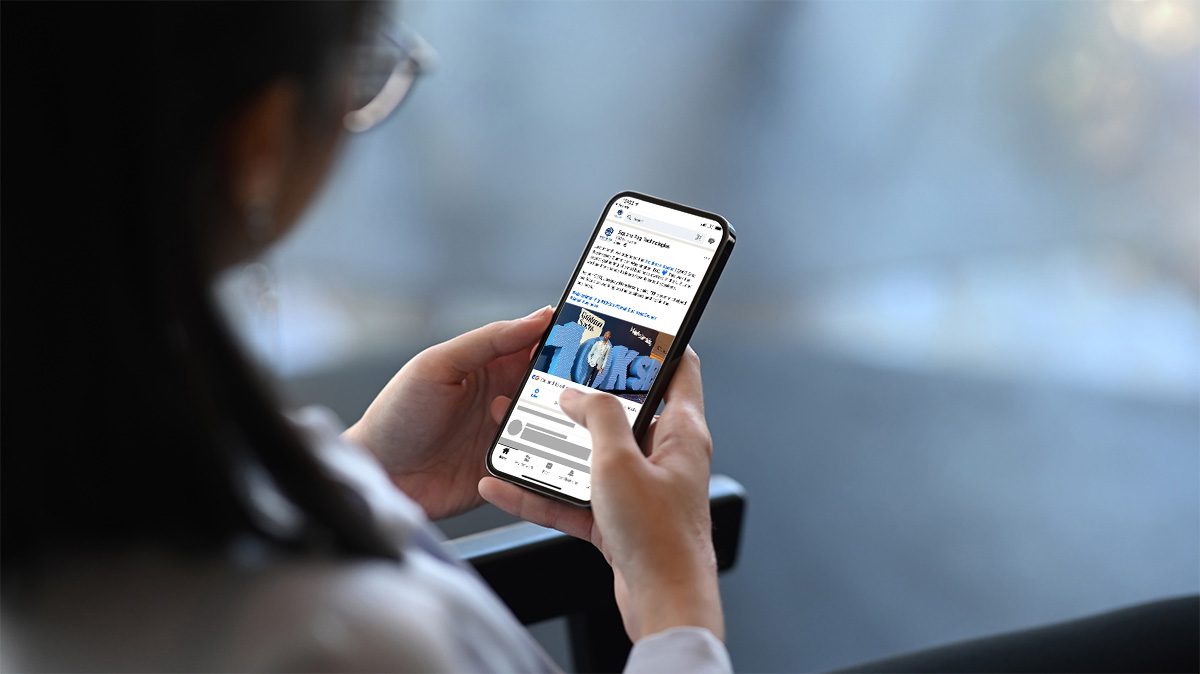 Business woman looks at a LinkedIn post from Square Peg Technologies on her phone