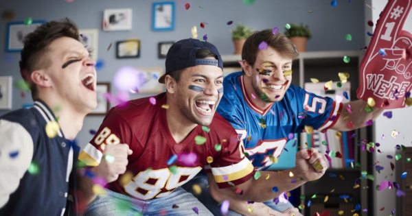 Three football fans celebrating while watching the game, an ideal audience for Super Bowl email marketing tactics