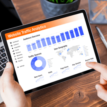 A person holding a tablet with website traffic analytics data displayed on it