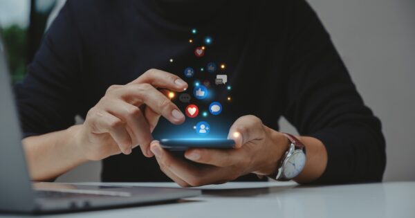 A staff member using LinkedIn from their phone with Sprout Social's Employee Advocacy