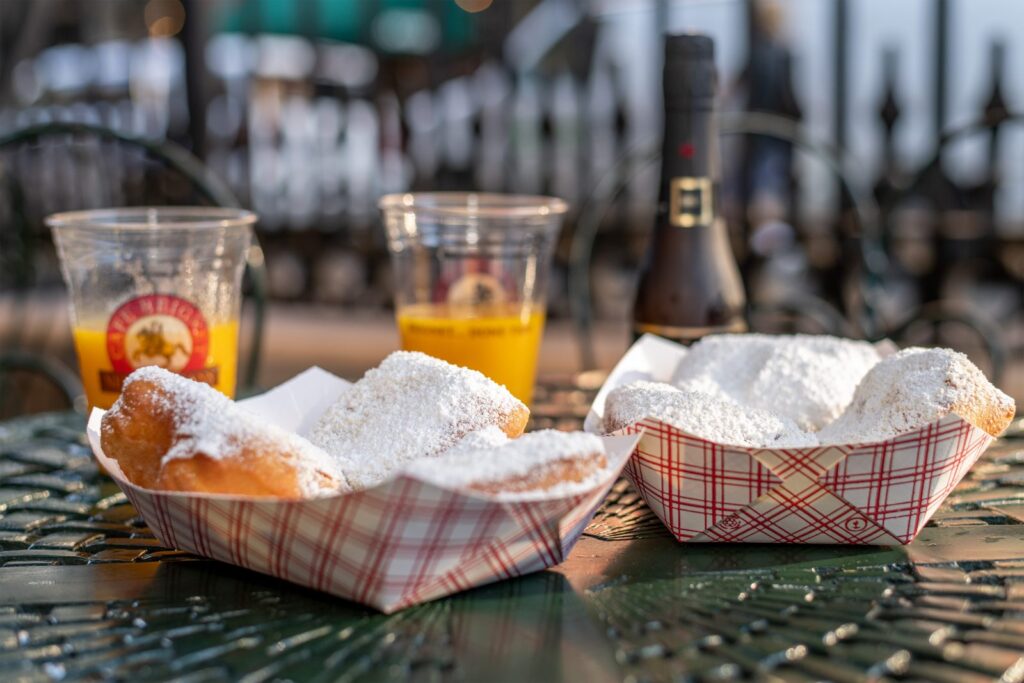 Beignets in red plaid paper containers at Cafe Beignet.