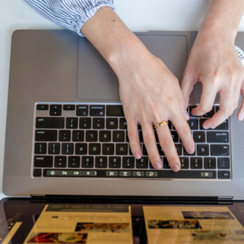 overhead shot of hands typing on a laptop