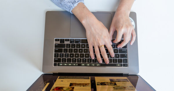 overhead shot of hands typing on a laptop