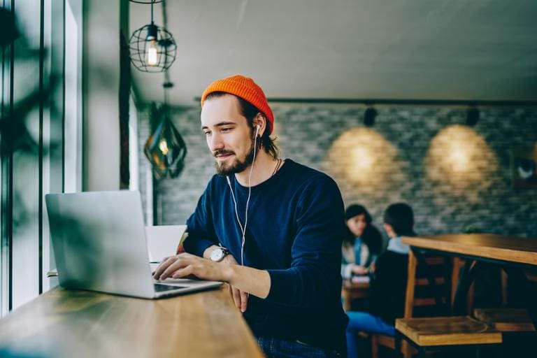 Web developer works on a laptop at a coffee shop