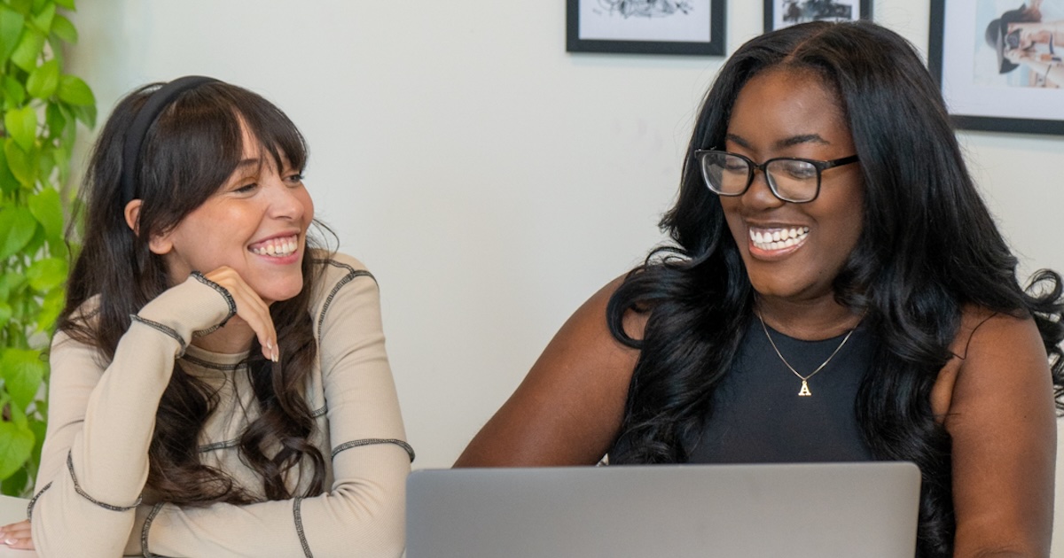 Jordan and Alyssa smiling at a laptop