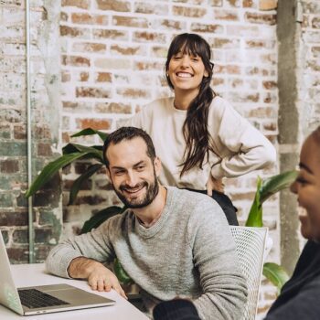 Sam, Jordan, and Alyssa talking and contributing to the work culture in our advertising agency