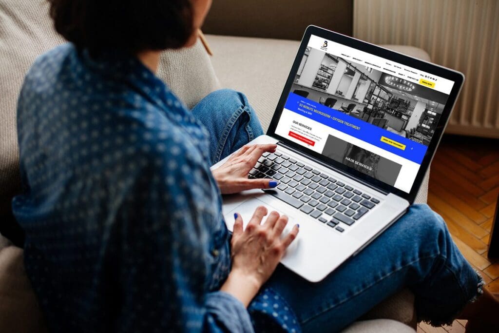 Woman uses Bauhaus Salon + Spa's new website on a laptop in her home