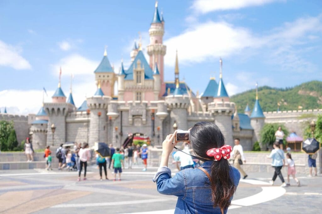 A tourist takes a photo of Sleeping Beauty's Castle at Hong Kong Disneyland.
