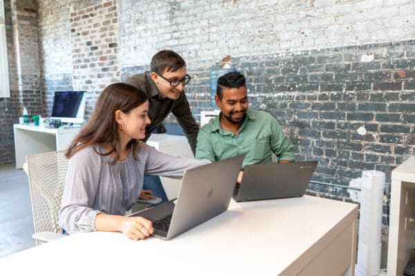 Esteban shows Flynn and Claire his work on a laptop, with Claire indicating something onscreen.