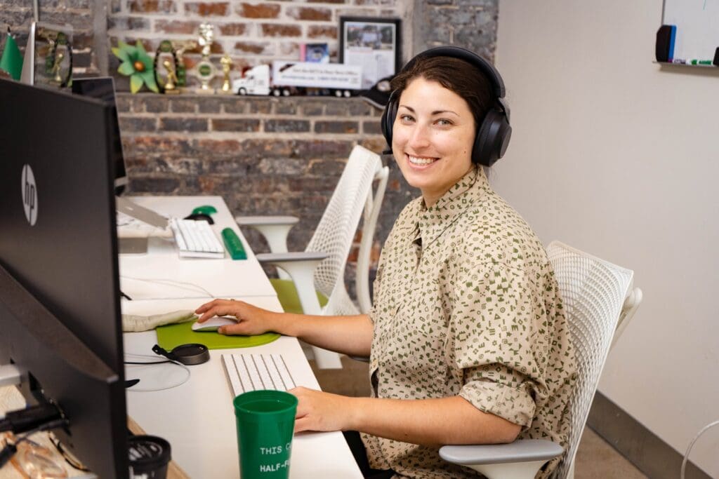Sara looks up from her work at her desk with a smile.