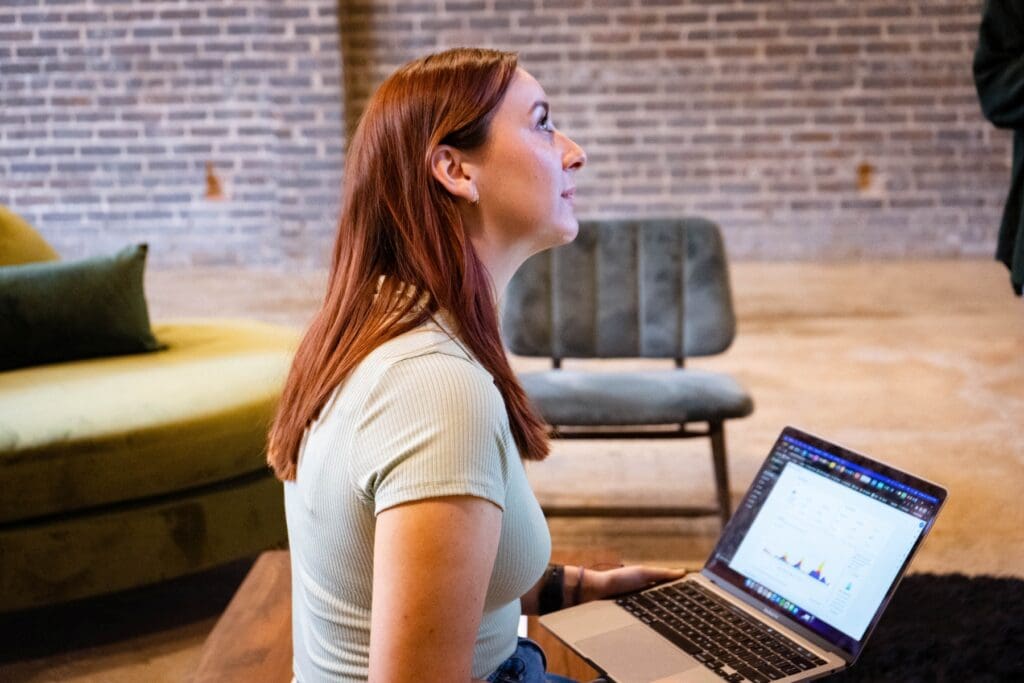 Madison looks up from her laptop at someone out of frame.