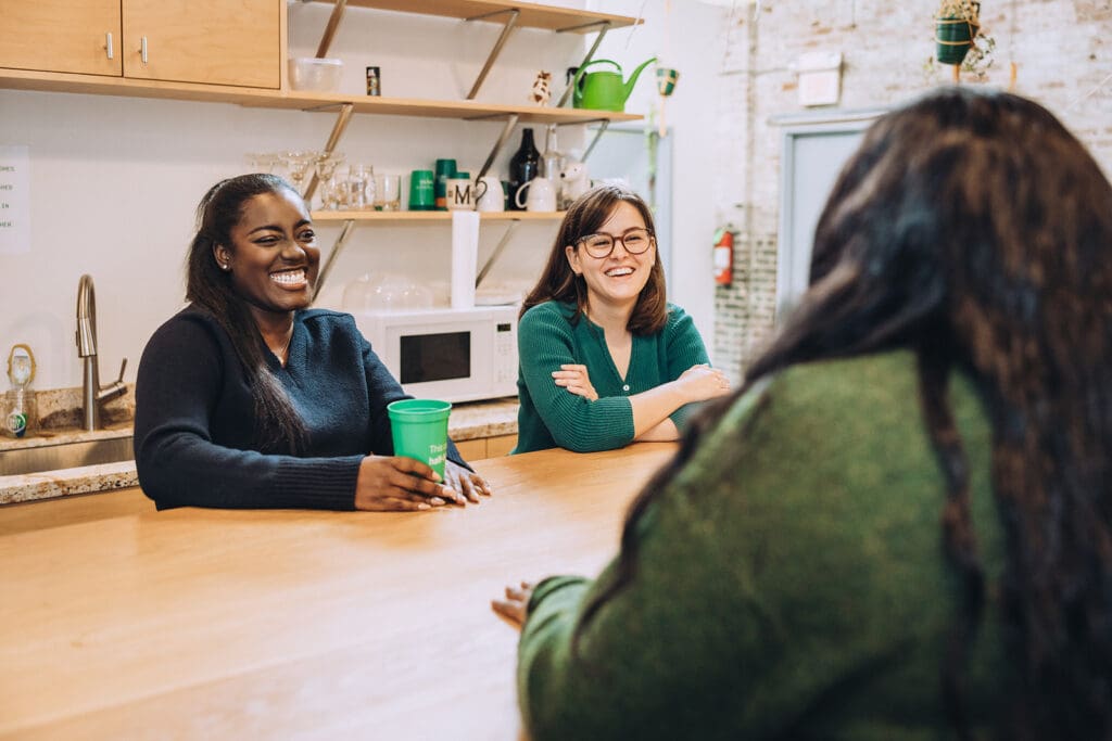 Alyssa and Claire chat with another person at the Online Optimism office.