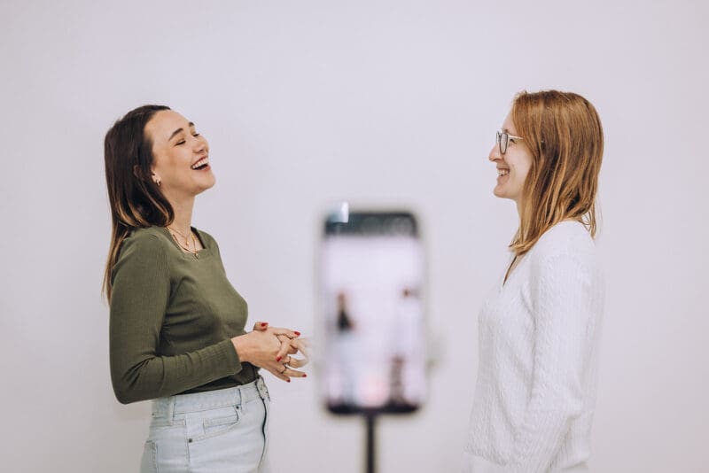 Meara laughs while talking to Lauren in front of an iPhone camera.