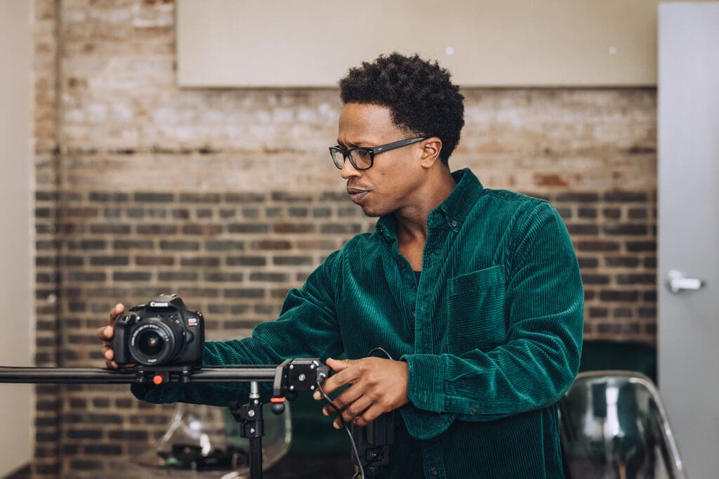 Daniel adjusts a camera while filming at the Online Optimism office.