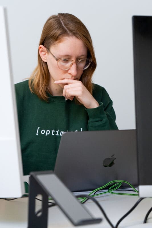 Lauren studies her laptop screen, deep in thought.