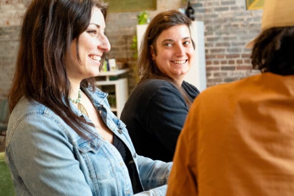 Amanda and Sara chatting and laughing at the Online Optimism office.