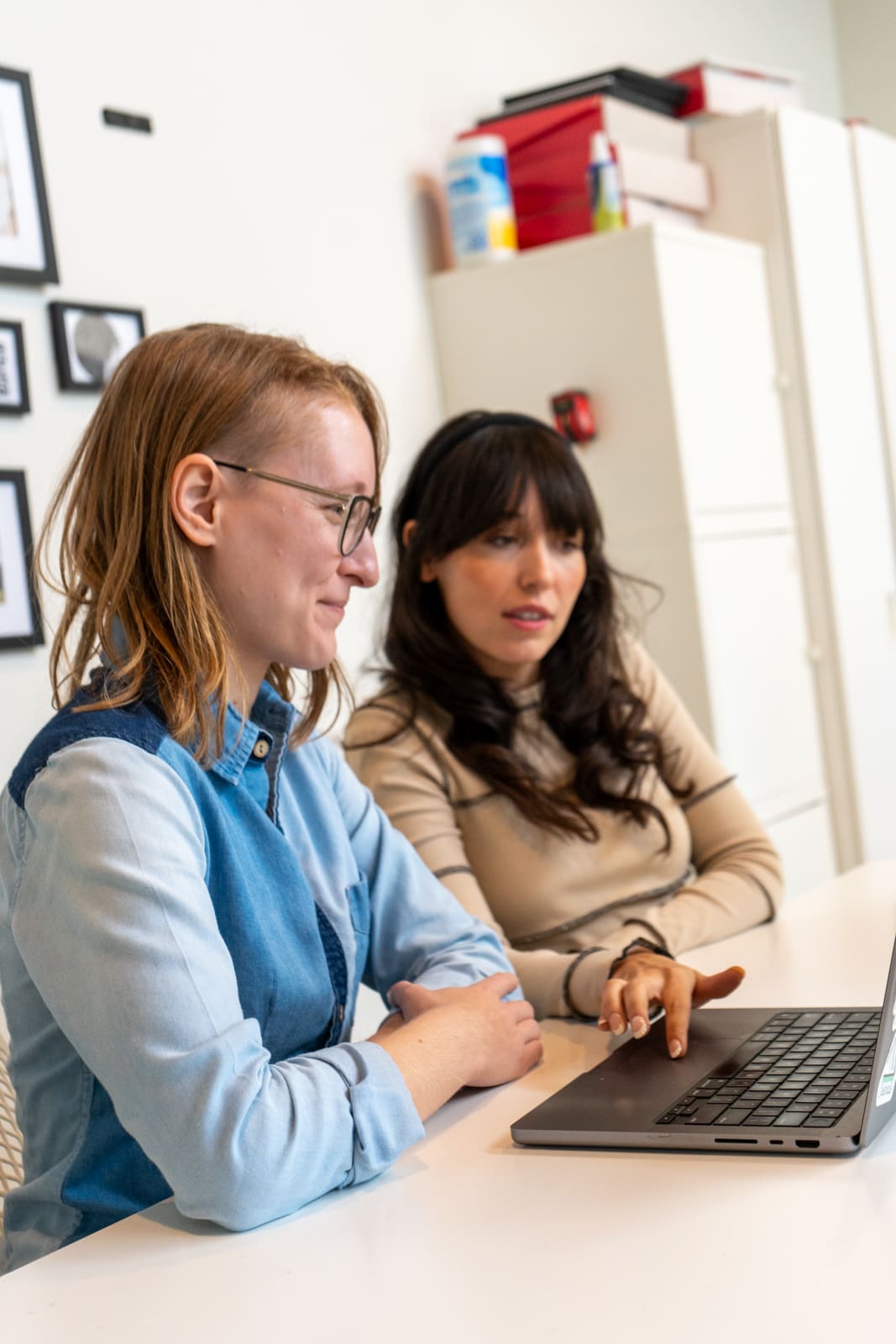 Lauren and Jordan work together on a laptop.