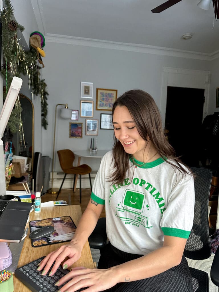Meara works from home, wearing an Online Optimism t-shirt.