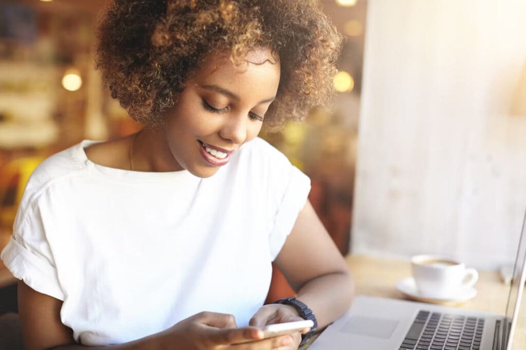 Woman smiles while using a cell phone