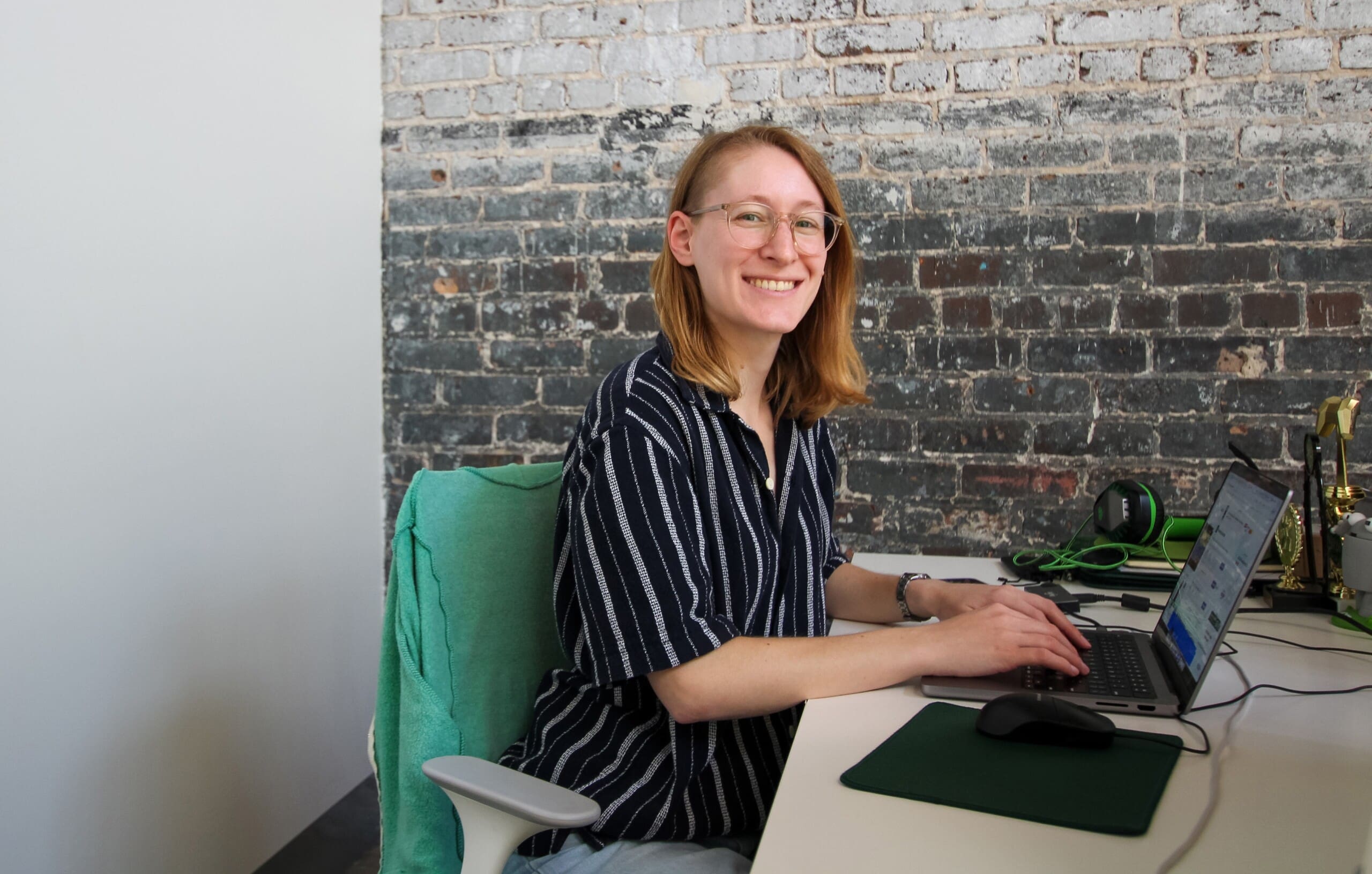 Lauren looks up from working on a laptop and smiles.