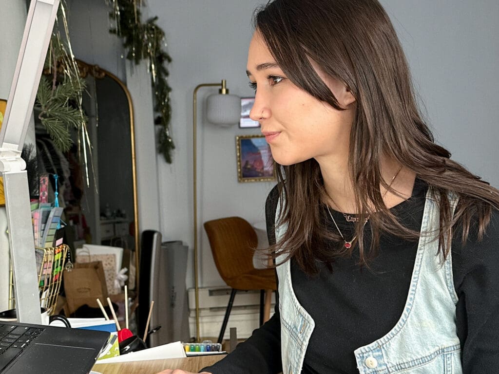 Meara focuses on a task at her home office desk.