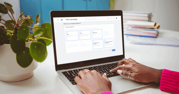 An Optimist working on on their laptop on a Google Ads campaign that is integrated with other marketing channels
