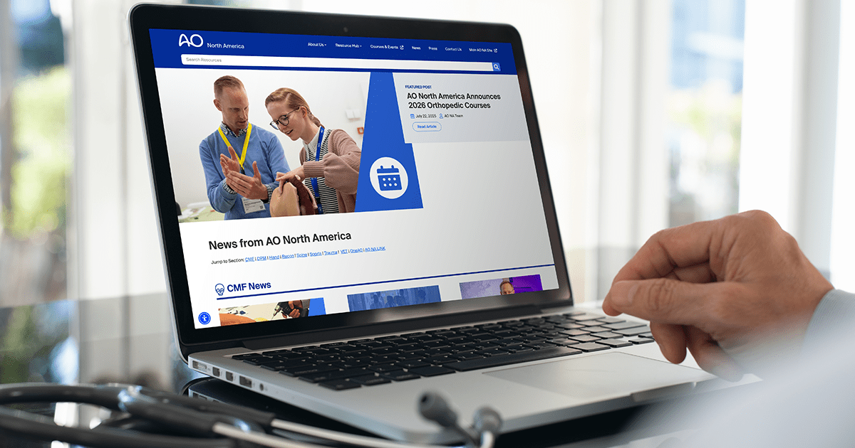 A doctor browses the AO North America blog on a laptop, with a stethoscope next to them.