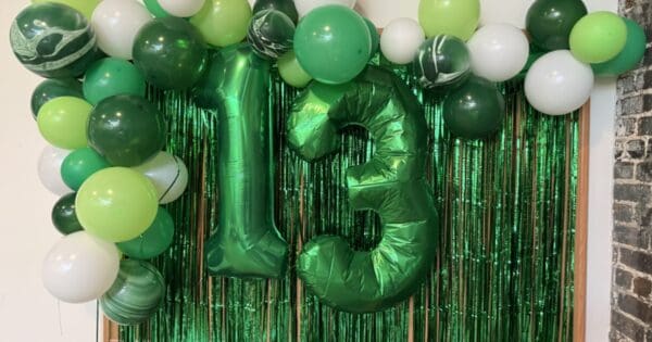 Green ballons with the number 13 surrounded by streamers