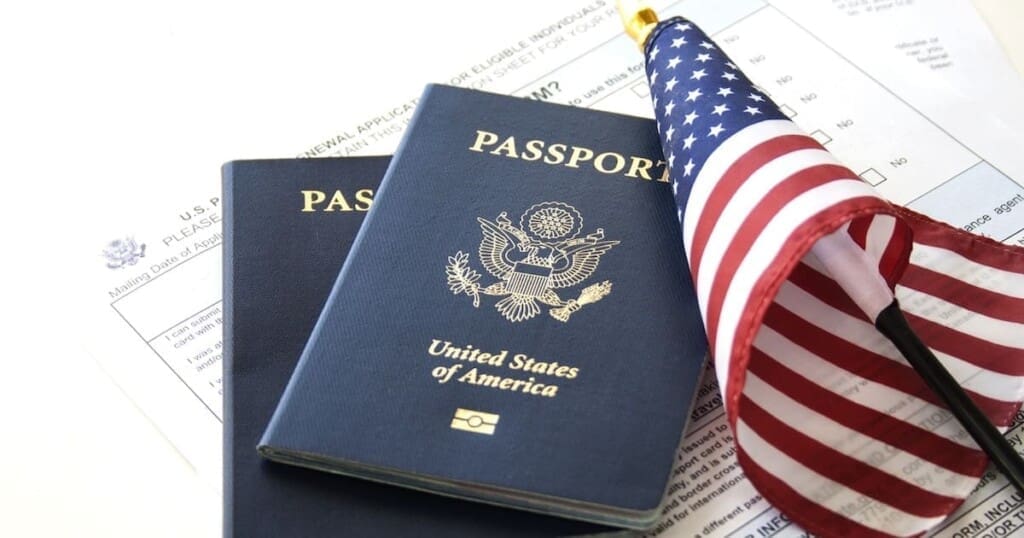 Two U.S. passports and an American flag over immigration paperwork