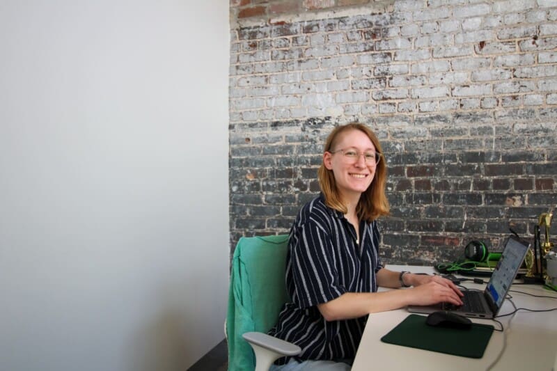 Lauren smiles while working at her desk in the office