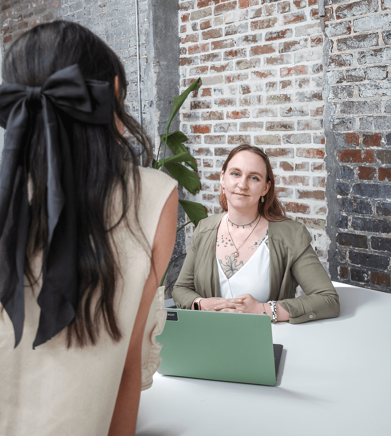 Jordan talks to Eliza who is working on a laptop.