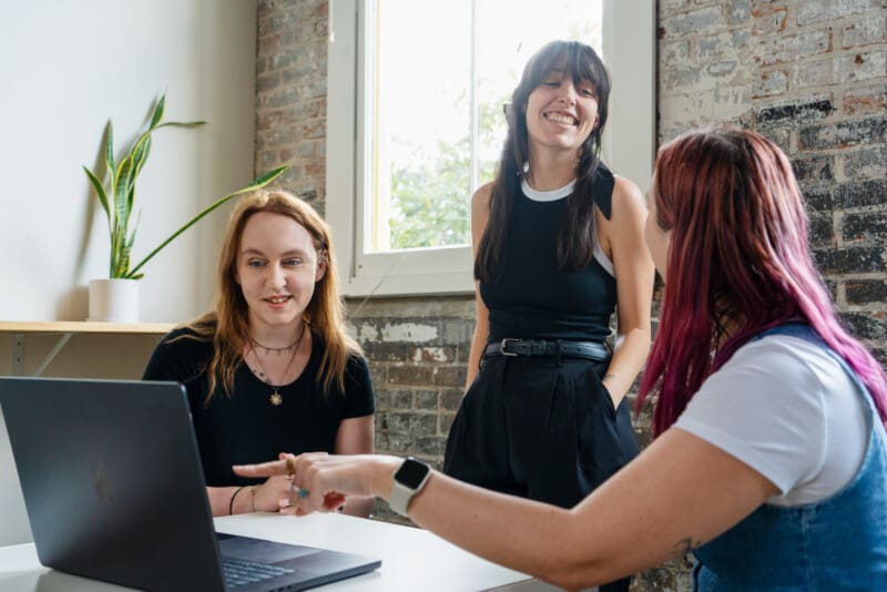 Eliza, Jordan, and Madison working on a Macbook together