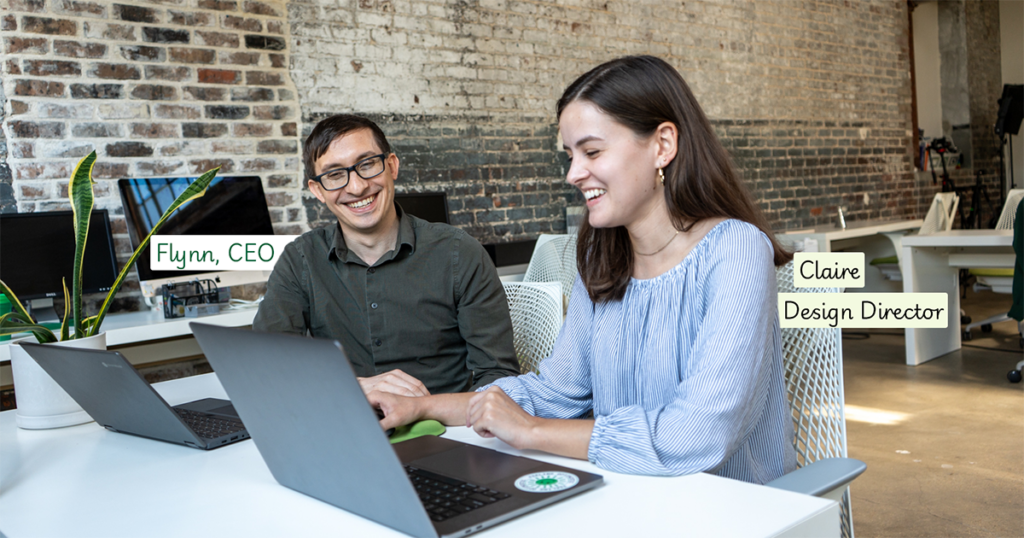 Flynn and Claire work together at a desk on their laptops