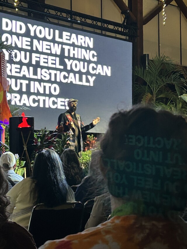 Ritest Gupta speaks in front of a projection screen which reads "Did you learn one new thing you feel you can realistically put into practice?"