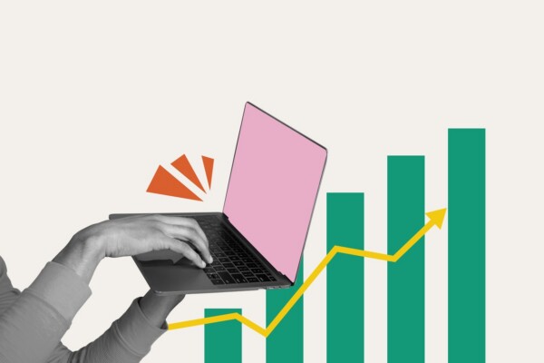 A hand typing at a computer over an illustration of a chart going up.