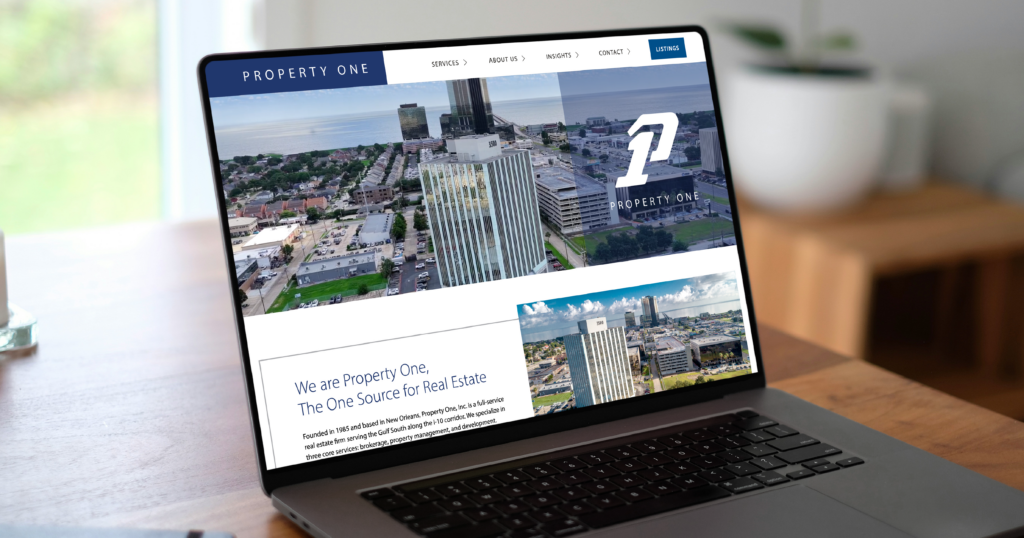 A visitor browses the Property One website on a laptop.