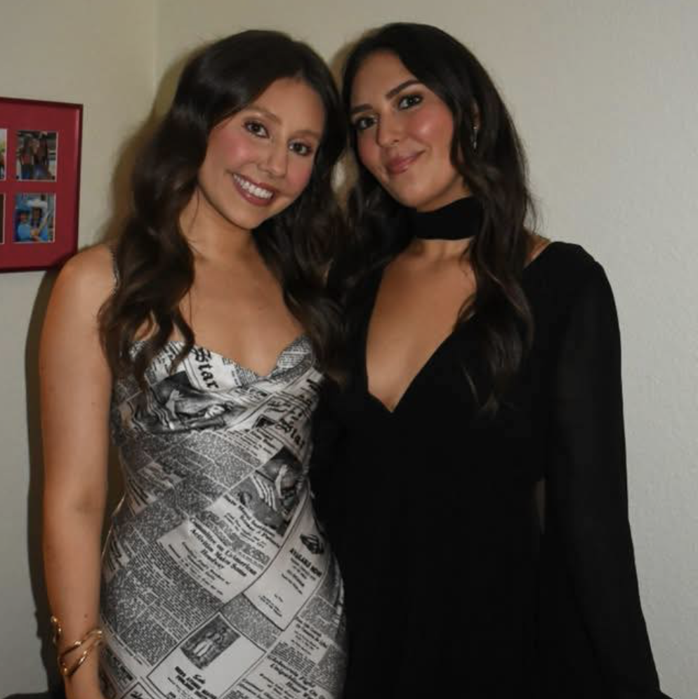 New Orleans influencers Fork With Us (Kaitlyn & Marigny Lanaux) pose together in black-and-white formal dresses.