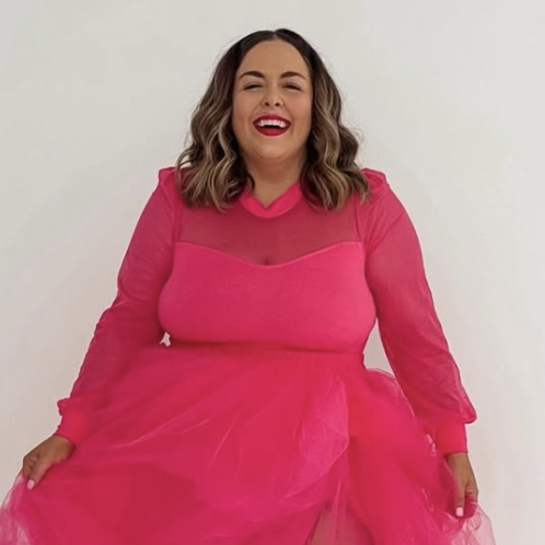 New Orleans influencer Mimosas and Lipstick (Hannah Wilson) laughs and smiles, wearing a hot pink tulle gown and vivid lipstick to match.